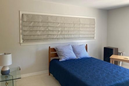 Elegant bedroom in Walnut Creek featuring fully lowered printed Roman window shades, adding privacy and visual appeal to a wide window.